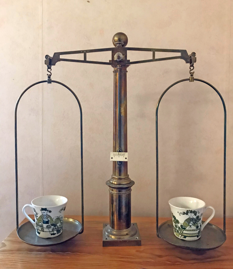 En gammeldags våg med två kaffekoppar som väger lika