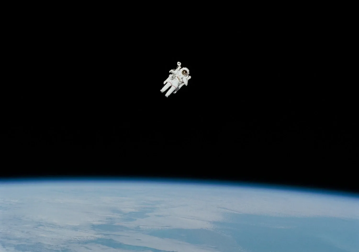 En astronaut svävar i rymden ovanför jordytan som syns nedanför