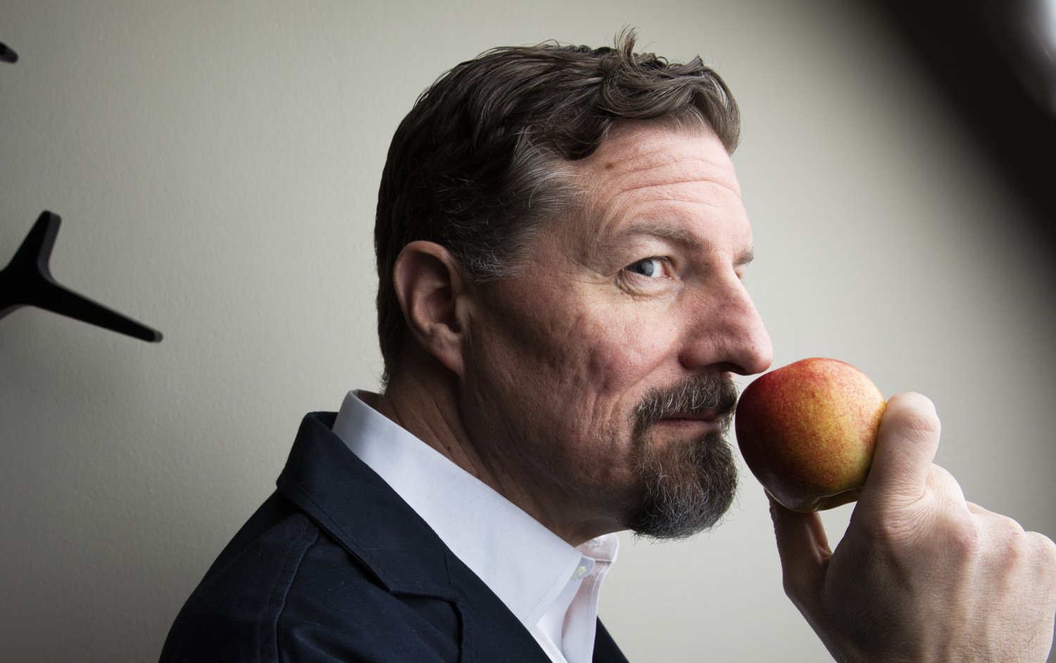 Professorn Johan Lundström håller ett äpple mot näsan.