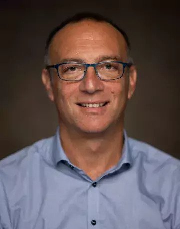 Porträtt av man i blå skjorta.