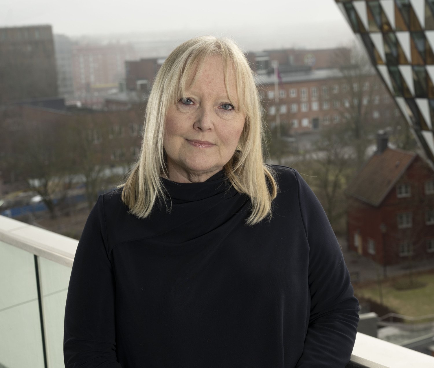 Porträtt av Ann Nordgren med fasaden av Aula Medica i bakgrunden