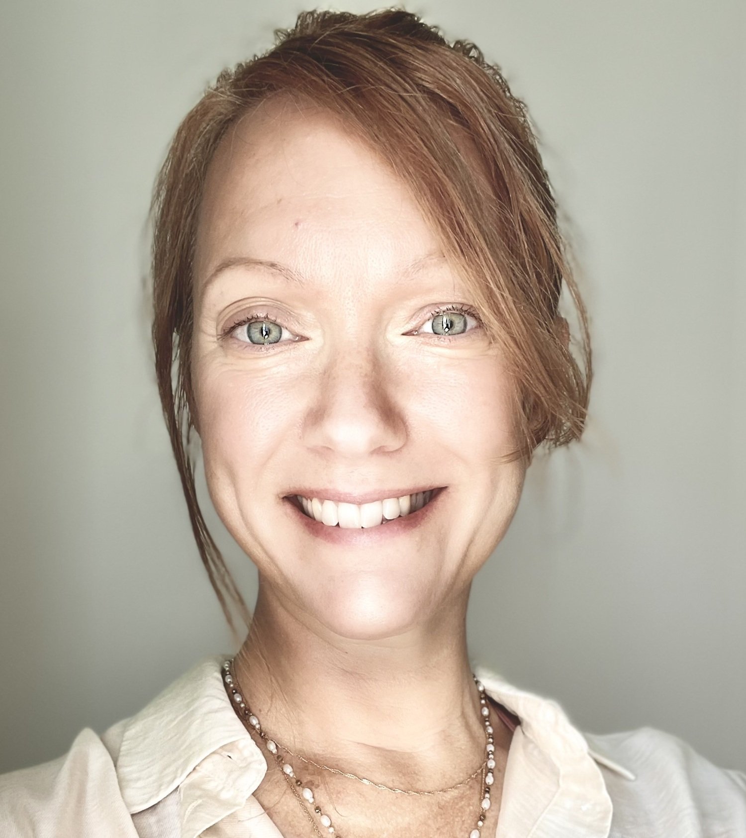 Porträtt av kvinna i ljus skjorta.