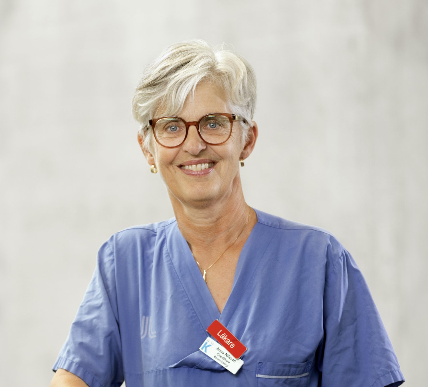 Porträtt av kvinna i blå läkarrock.