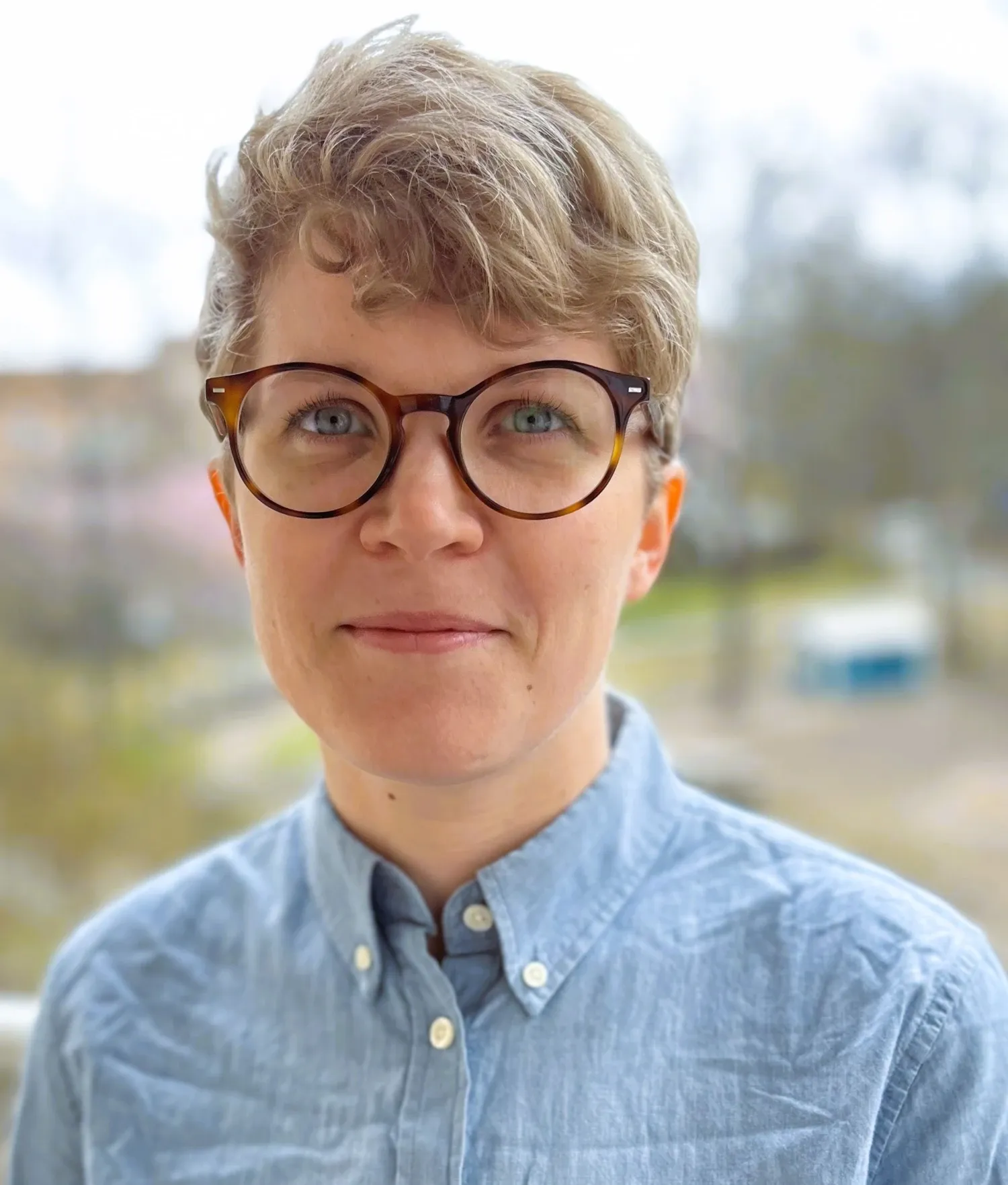Porträtt av kvinna i blå skjorta.