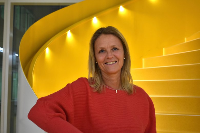 Helena Karlström, forskare och avdelningschef vid avdelningen för neurogeriatrik, NVS, står i engul trapp som svänger upp åt höger bakom henne.