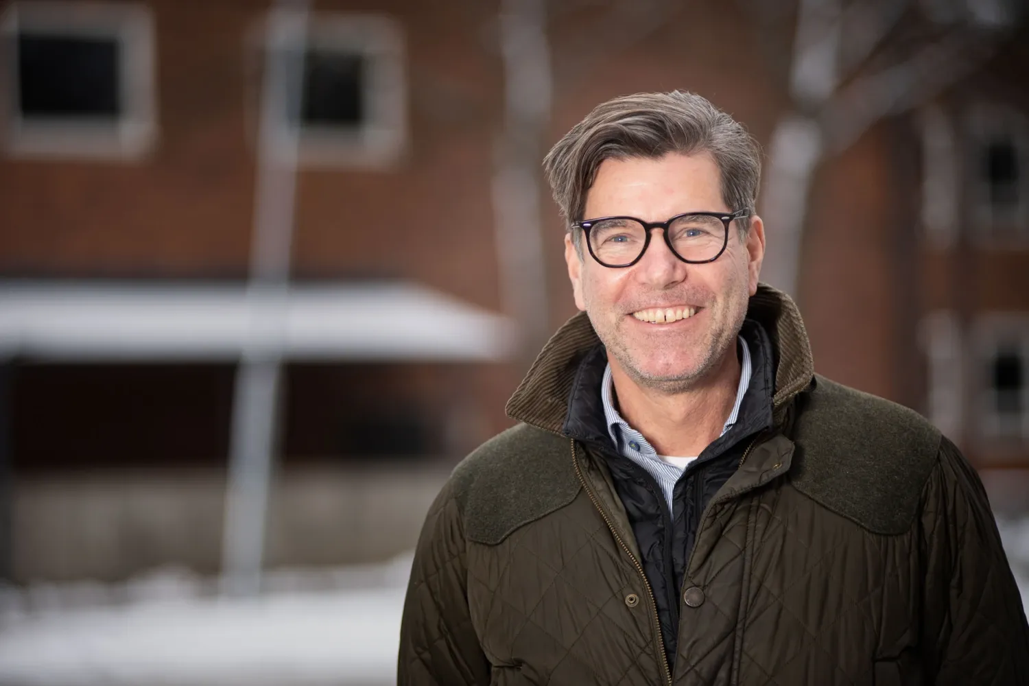 Utomhusporträtt på Björn Kull med byggnad i bakgrunden.