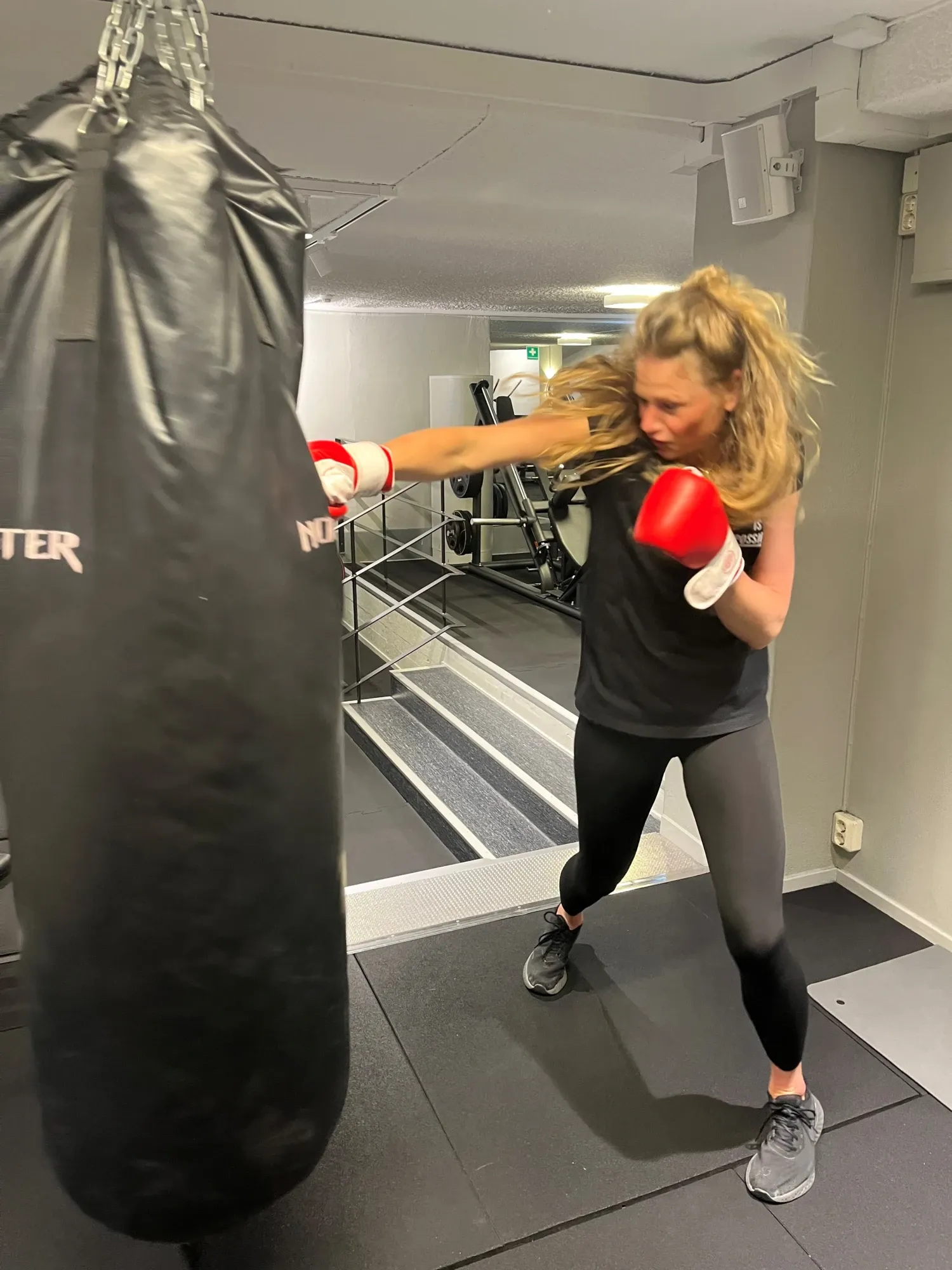 Pernilla Alencar Siljehag tränar boxning i gymmet och slår på boxningssäck med höger arm.