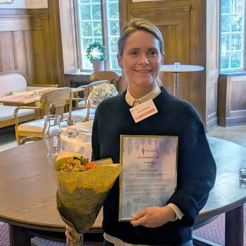 Forskare med blommor och diplom i handen