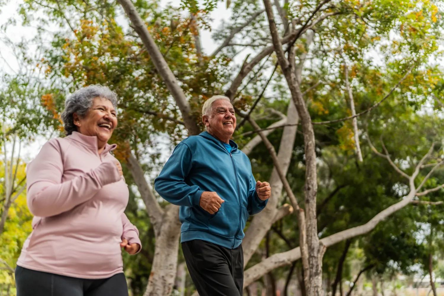 Ett äldre par som pratar och joggar i en offentlig park
