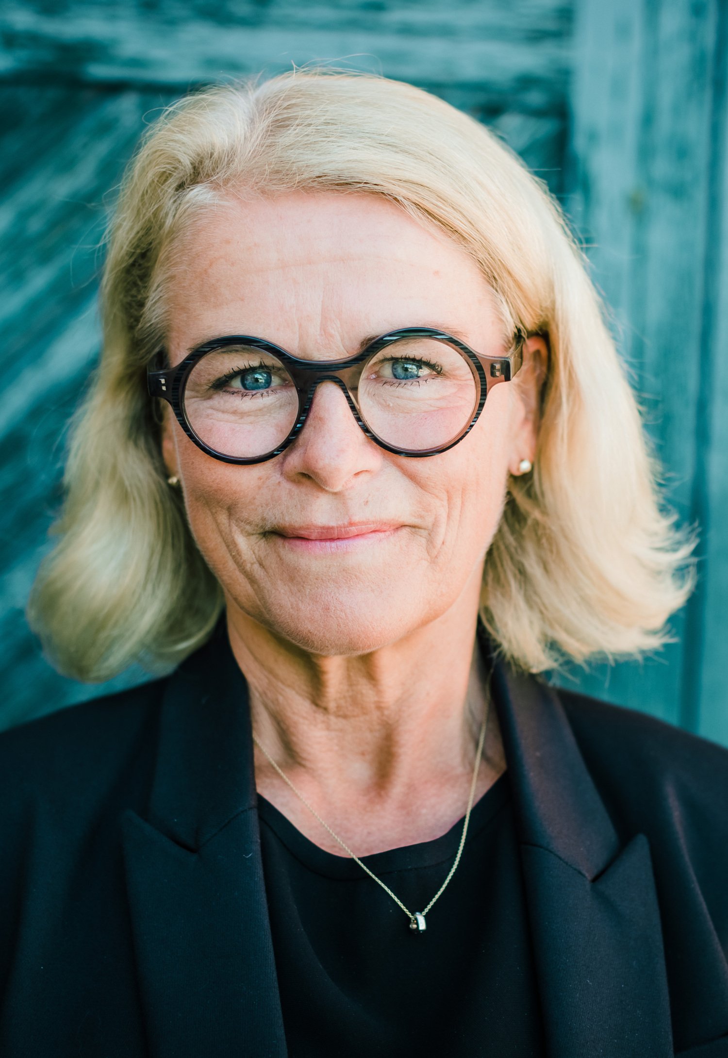 Porträtt av kvinna i mörkblå kavaj.