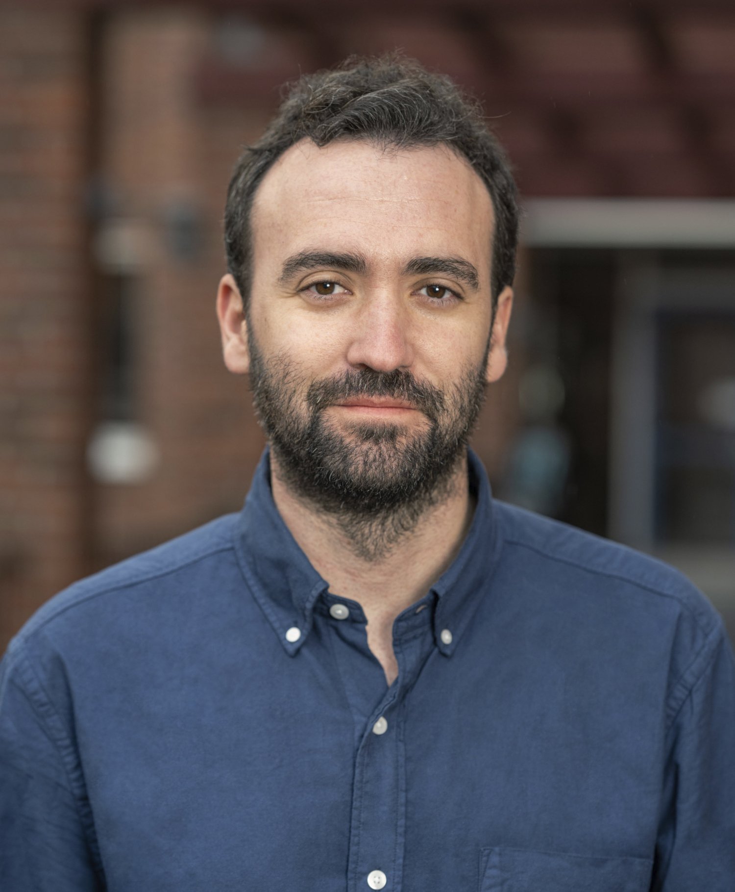 Porträtt av man i blå skjorta.