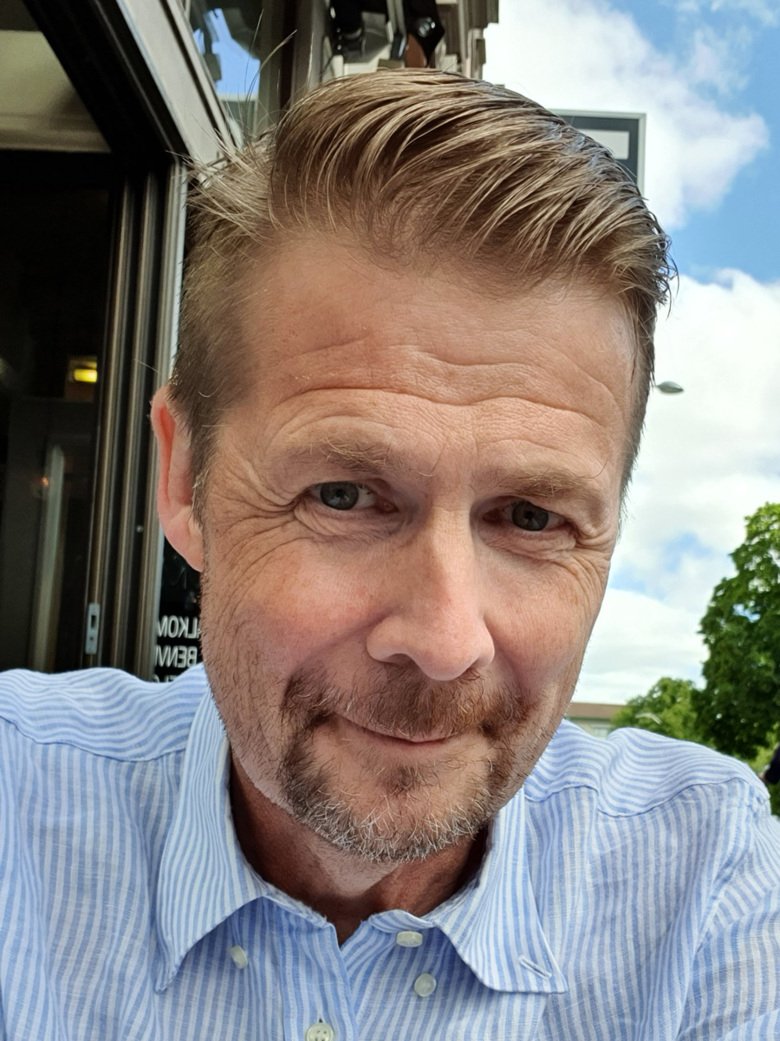 Selfie på Erik Lundström som sitter utomhus.