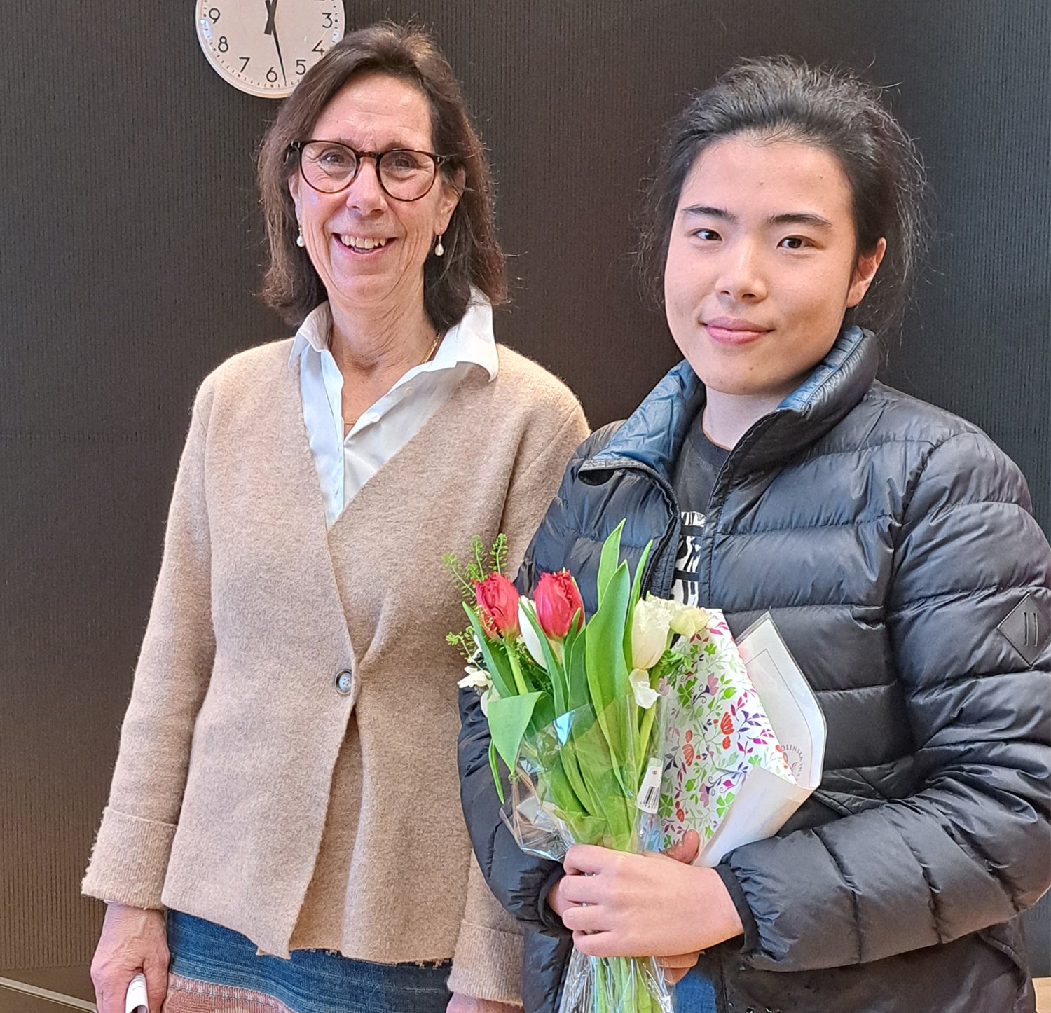 Kursansvarig och bästa student med blommor i famnen