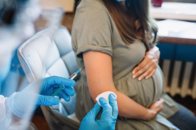 Gravid kvinna som sitter på en stol och ska få ett vaccin.