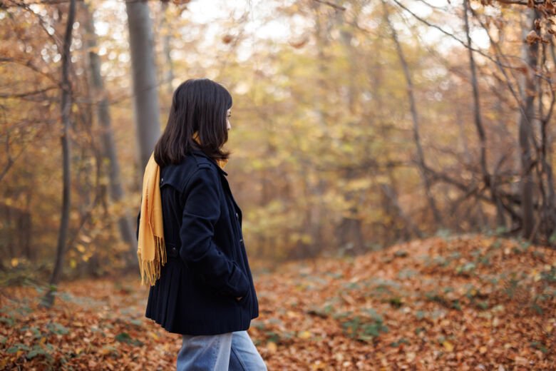 Ung kvinna promenerar i skog