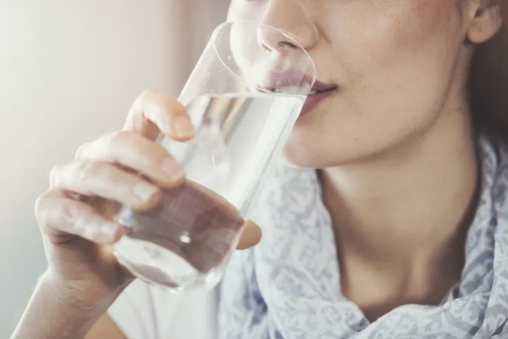 Kvinna som dricker ett glas vatten