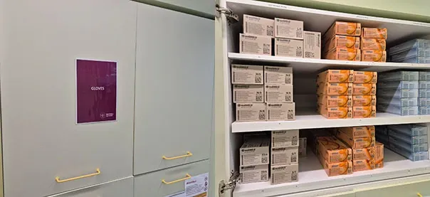 Bild på ett förvaringsskåp med lådor av plasthandskar staplade på hög.