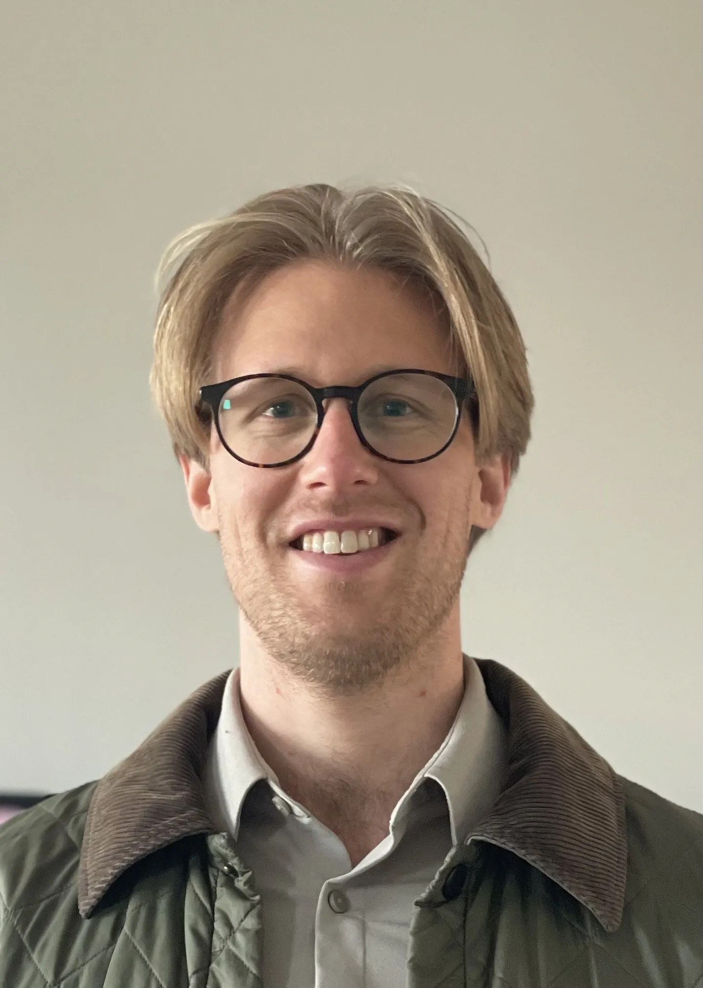 Porträtt av en blond man med glasögon.