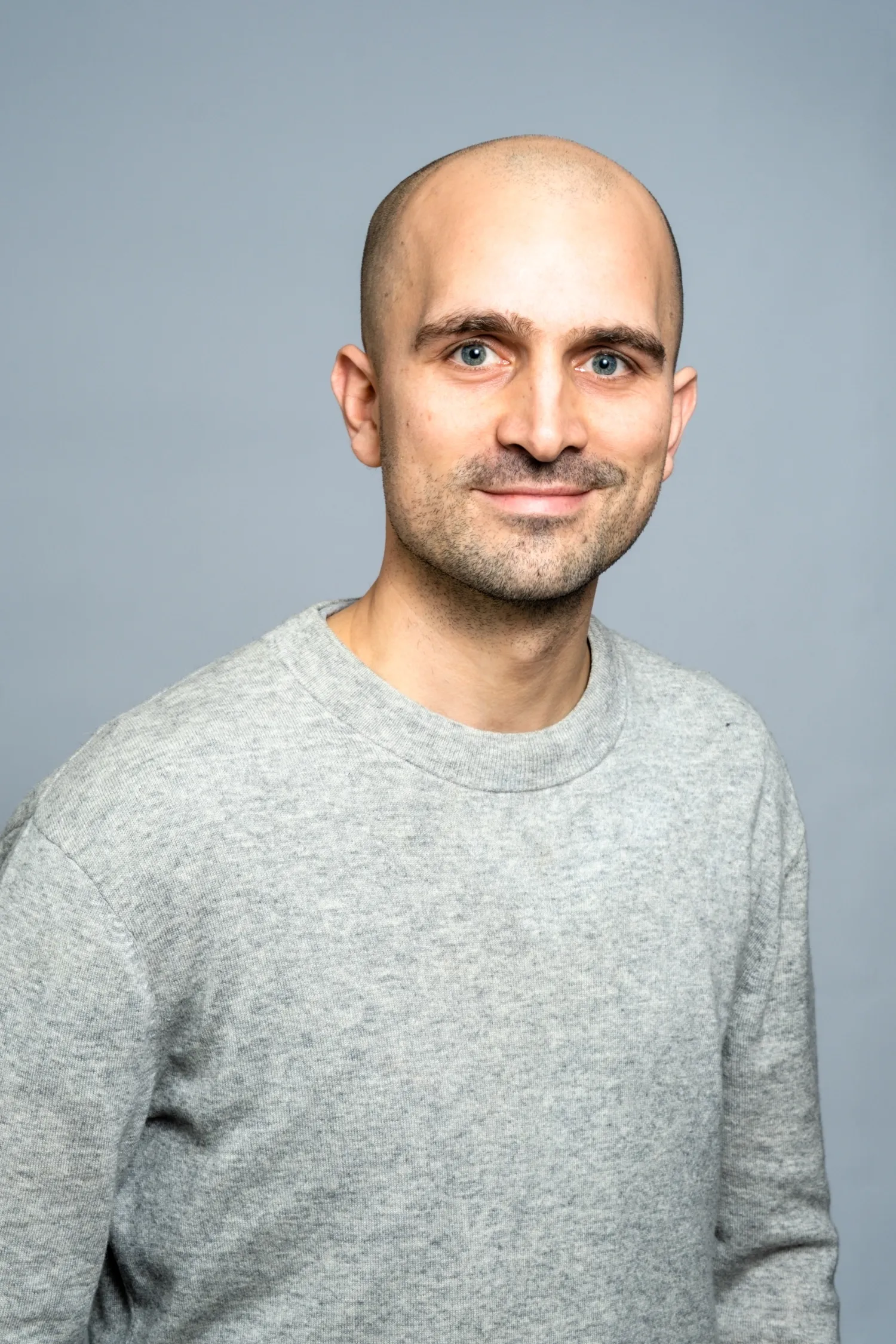 Porträtt av man i grå tröja.