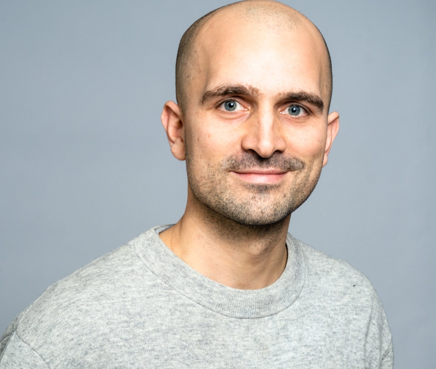 Porträtt av man i grå tröja.