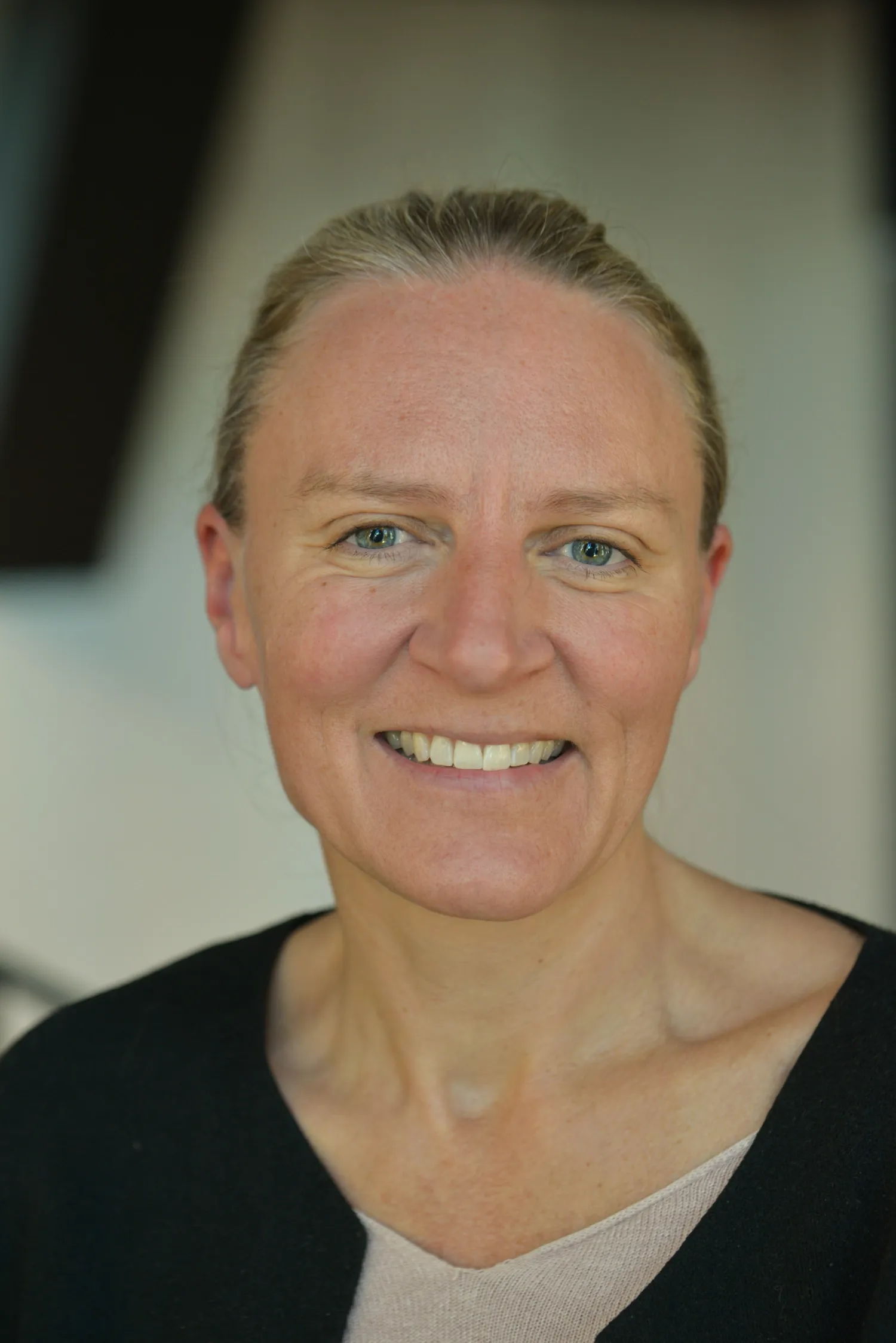 Kvinna som ler mot kameran.