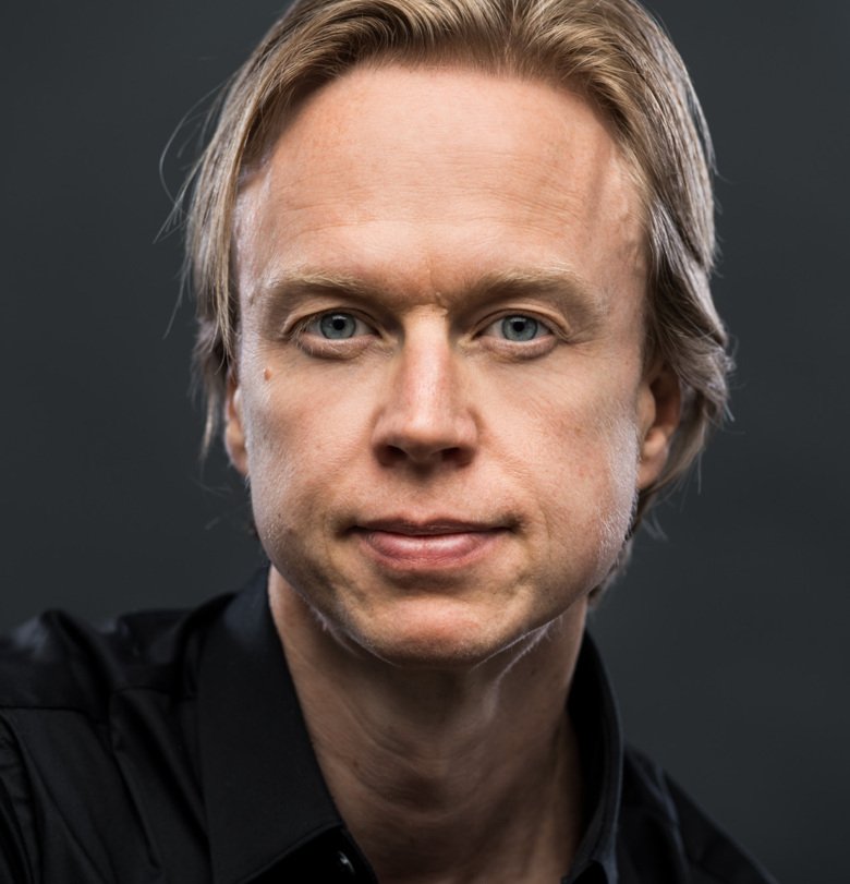 Porträttbild på Henrik Ehrsson, mot mörk bakgrund