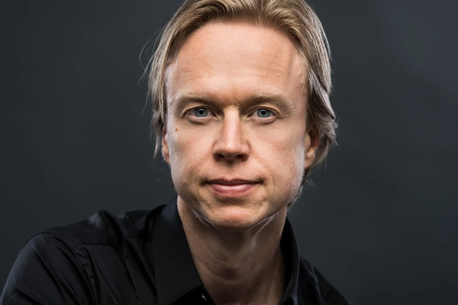 Porträttbild på Henrik Ehrsson, mot mörk bakgrund