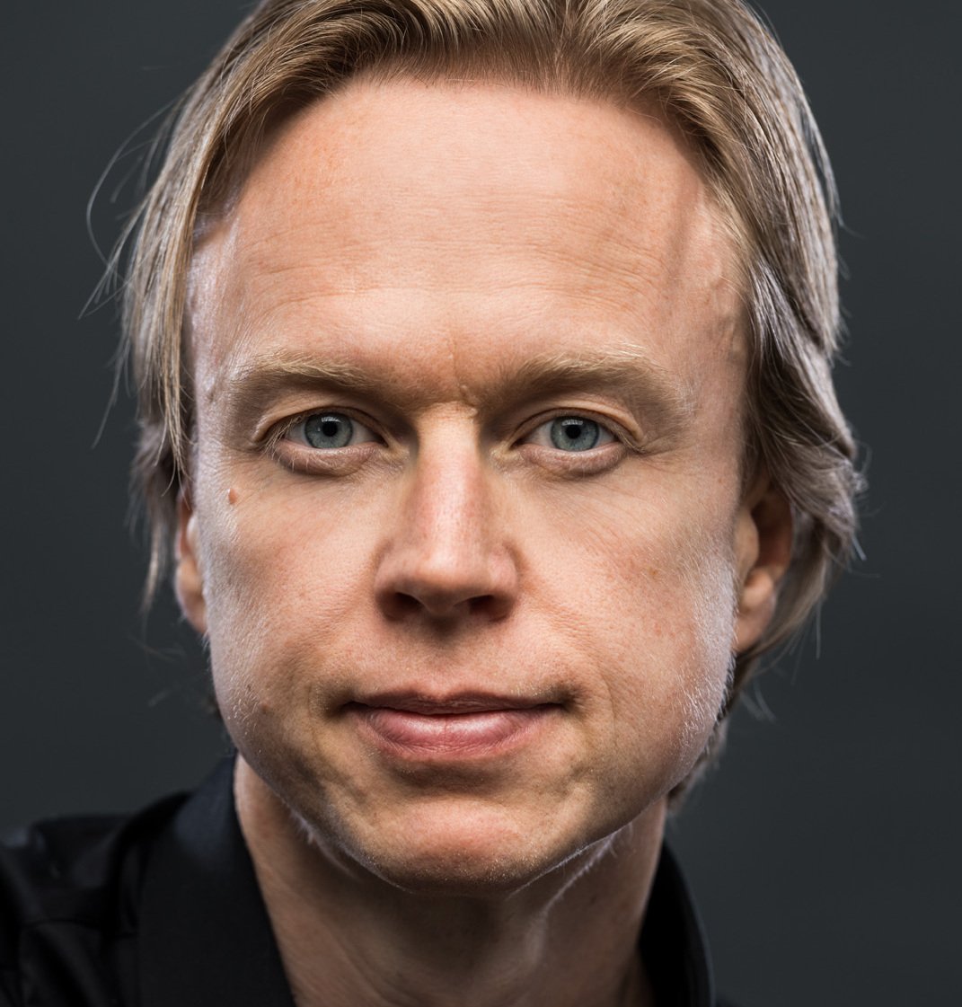 Porträttbild på Henrik Ehrsson, mot mörk bakgrund