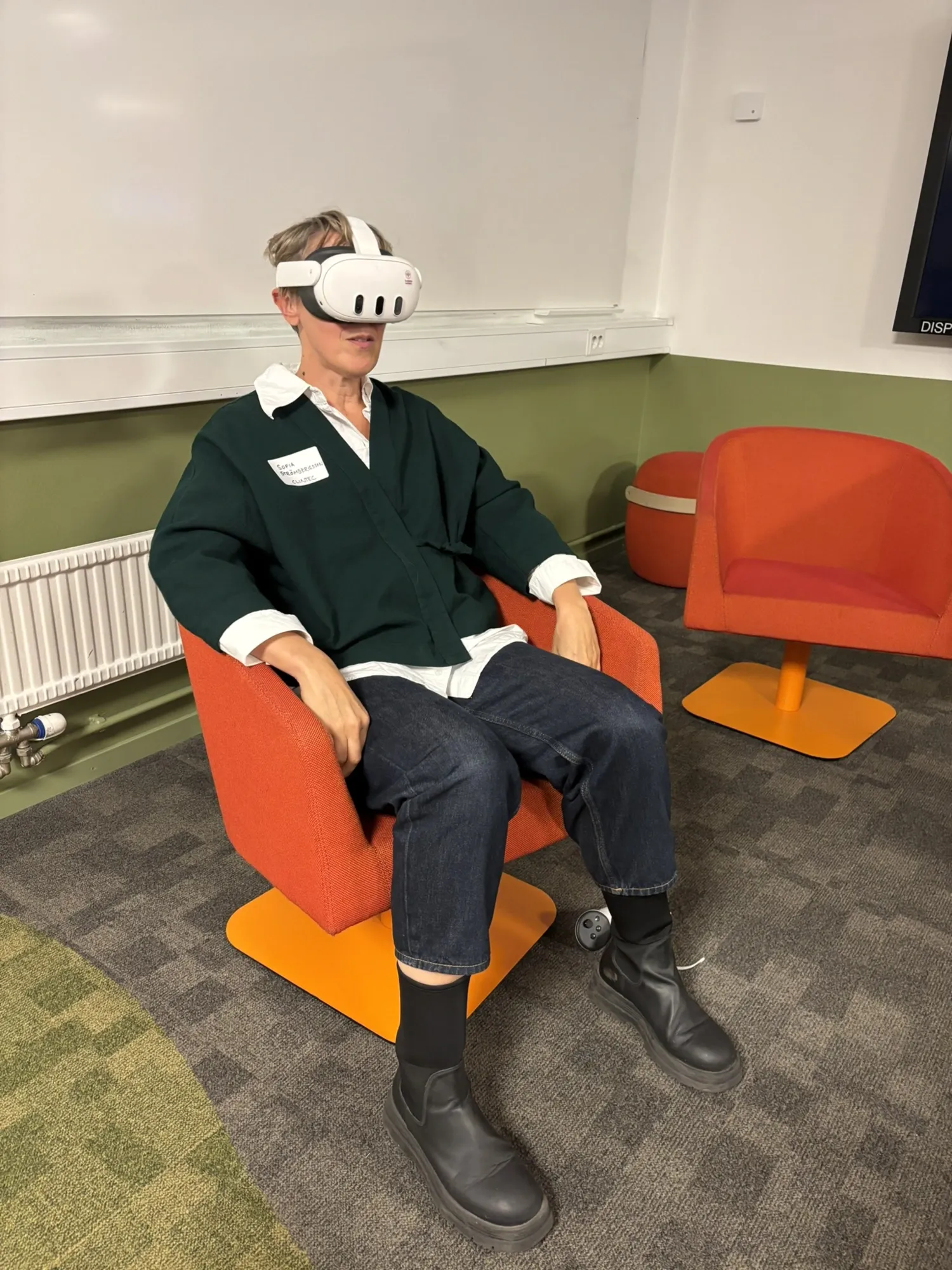 Sofia sitter i fåtölj med XR-glasögon på.