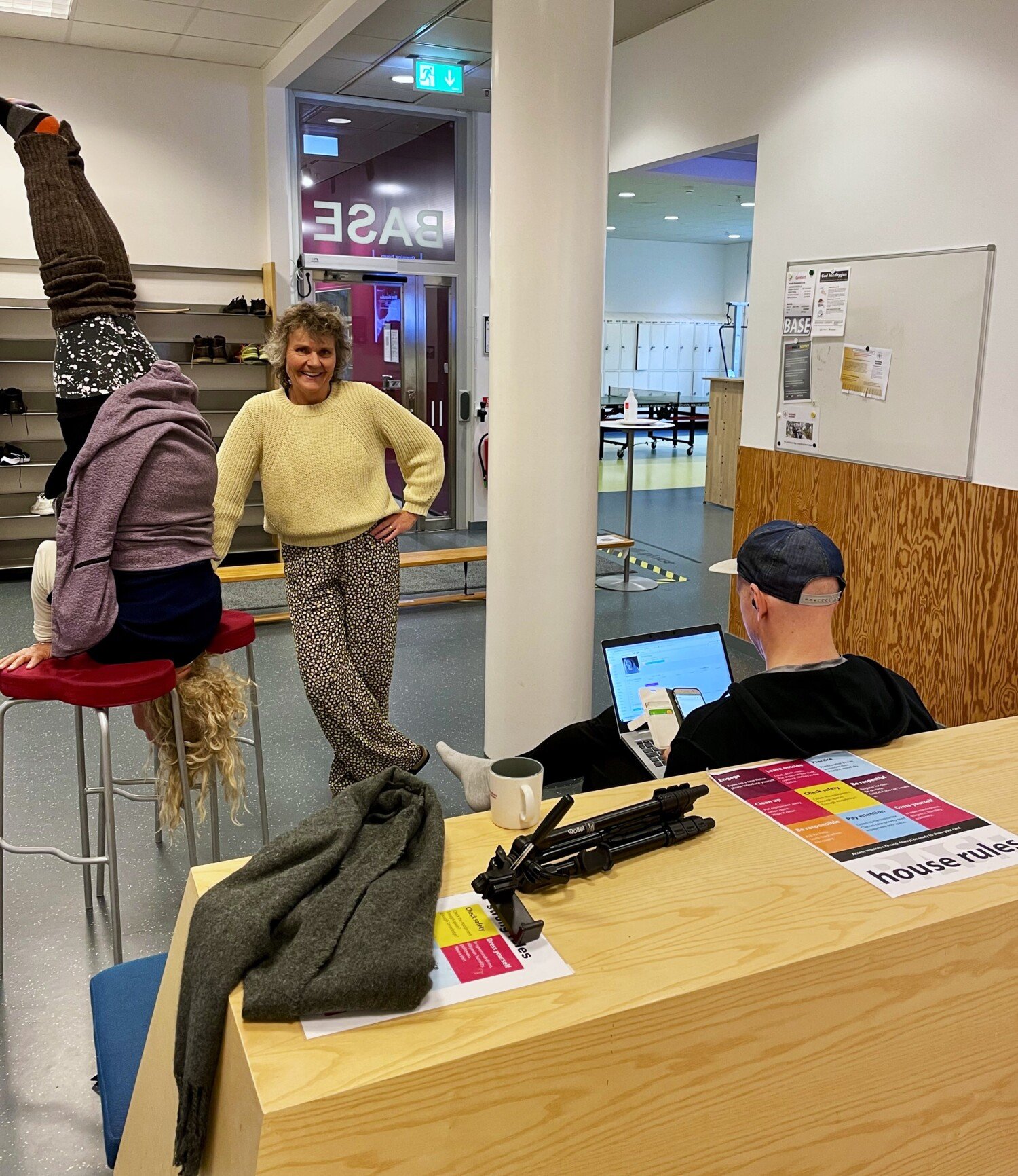 Tre medarbetare: en står, en jobbar vid laptop och en står på huvudet.