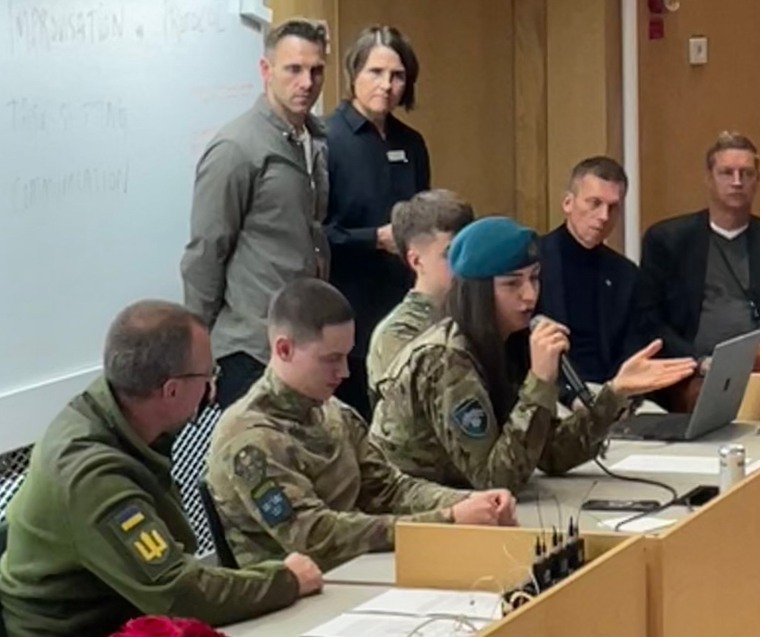 Ukrainska stridssjukvårdare i ett panelsamtal i en stor konferenssal.