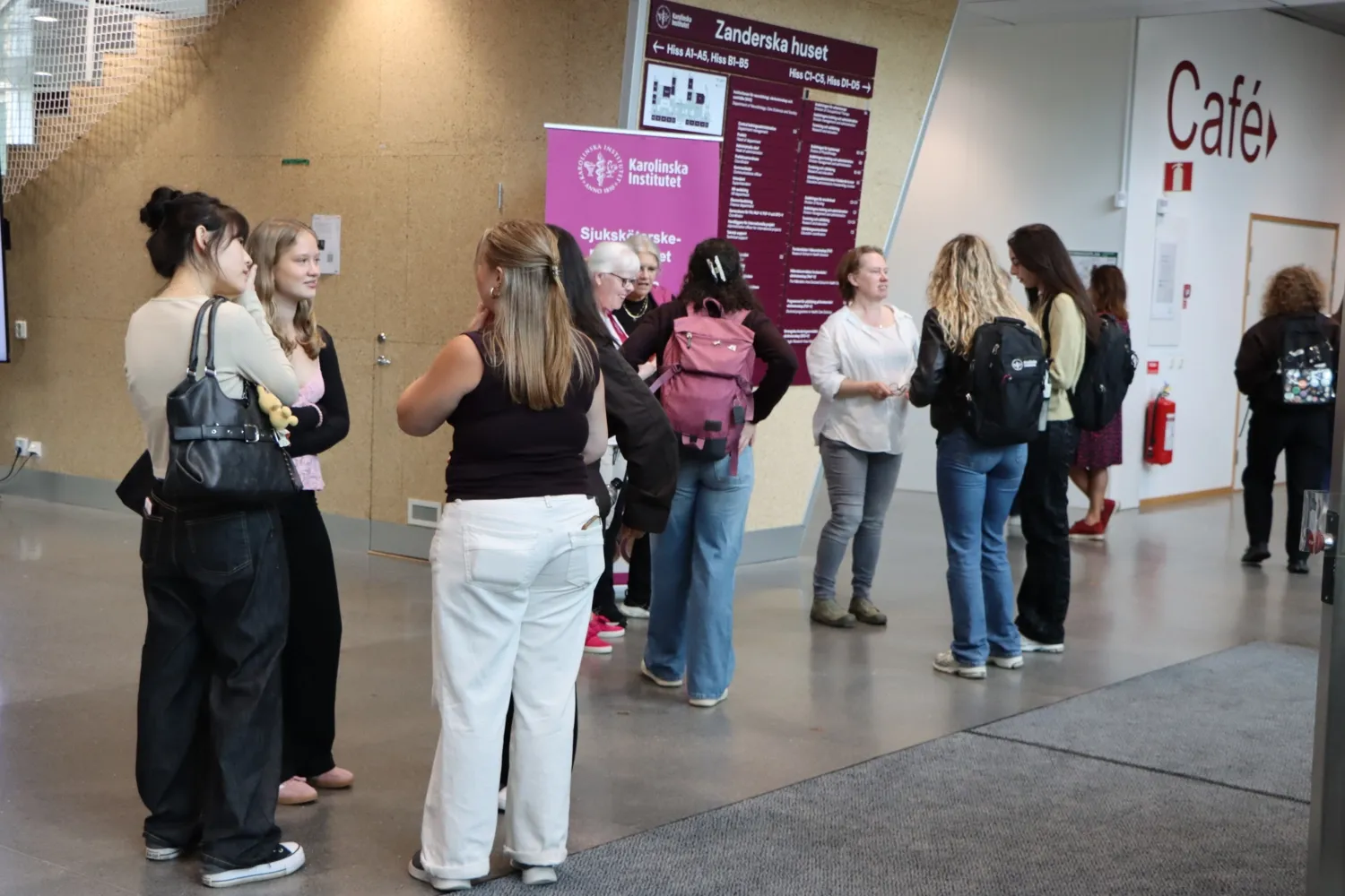 Folksamling innanför ANA 23:s entré. Nya sjuksköterskestudenter får hjälp av medarbetare från utbildningskansliet att hitta rätt.