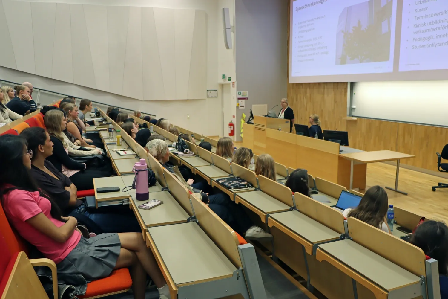Studenter sitter i H1 och lyssnar på Kristina Gottberg, PD, som pratar från podiet.
