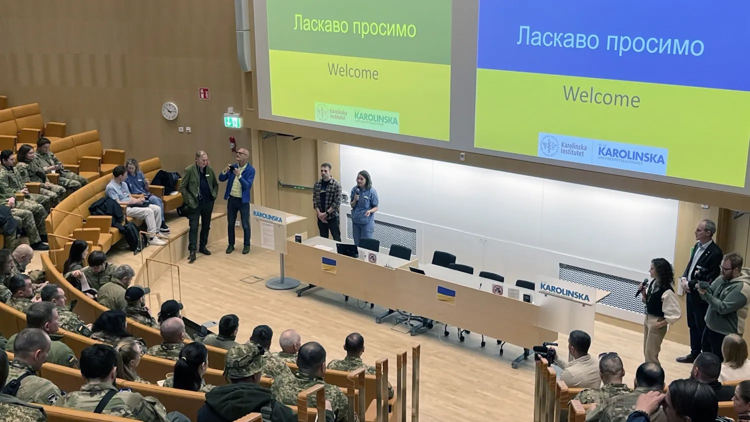 Ukrainska hälsoarbetare besöker Stockholm. och är samlade i aulan. På skärmen står Välkommen.