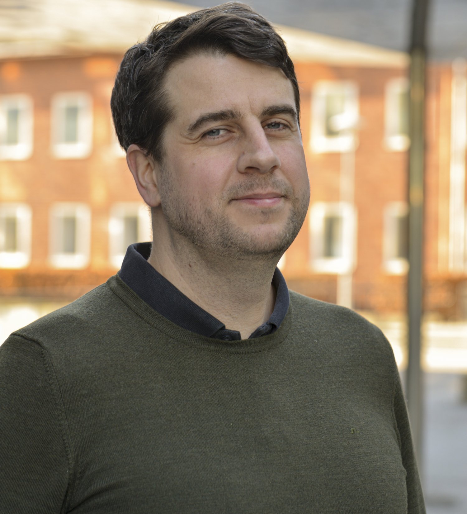 Porträtt av man i grön tröja.