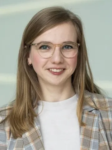 Porträtt av kvinna i ljus tröja och kavaj.