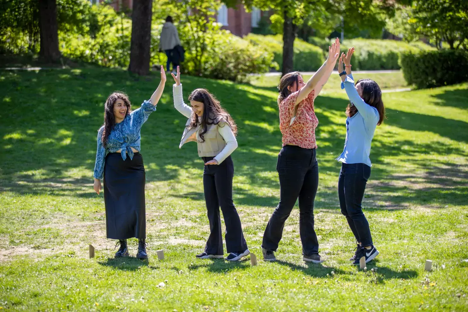 Studenter spelar kubb på gräsmattan utanför universitetsbiblioteket på campus Solna.