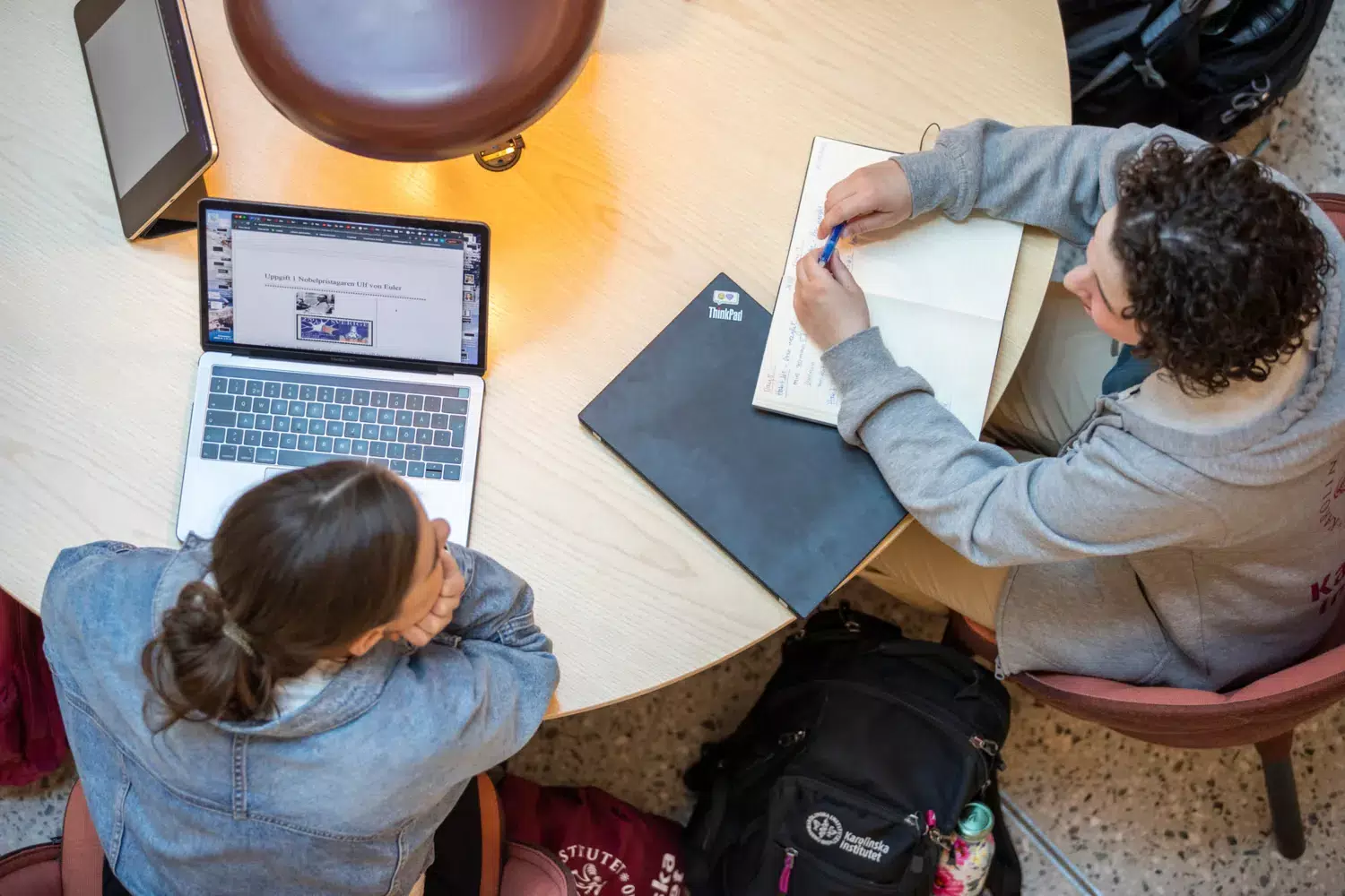 Två studenter sitter vid ett bord och samtalar