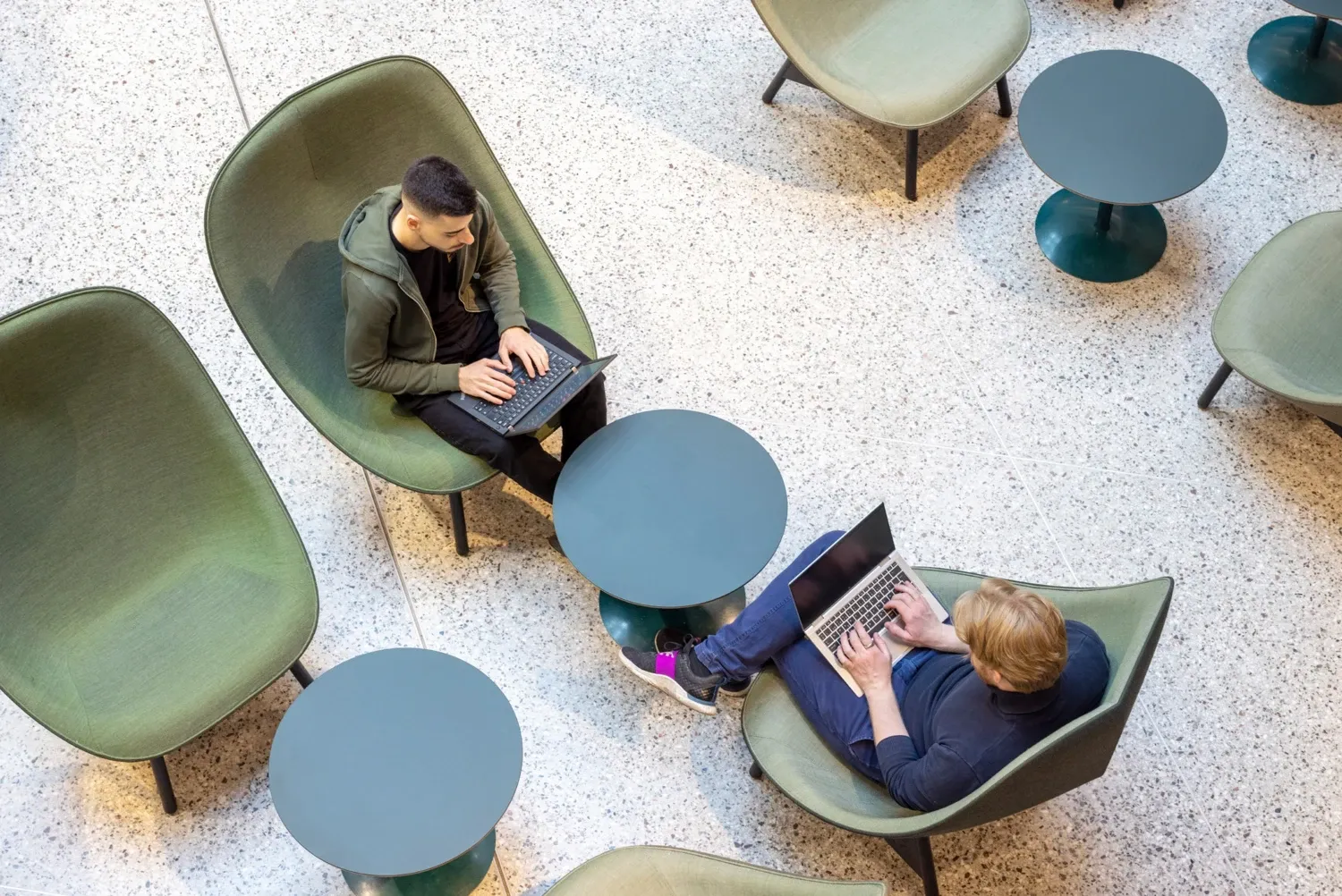 Två studenter som pluggar med laptops på campus Solna.