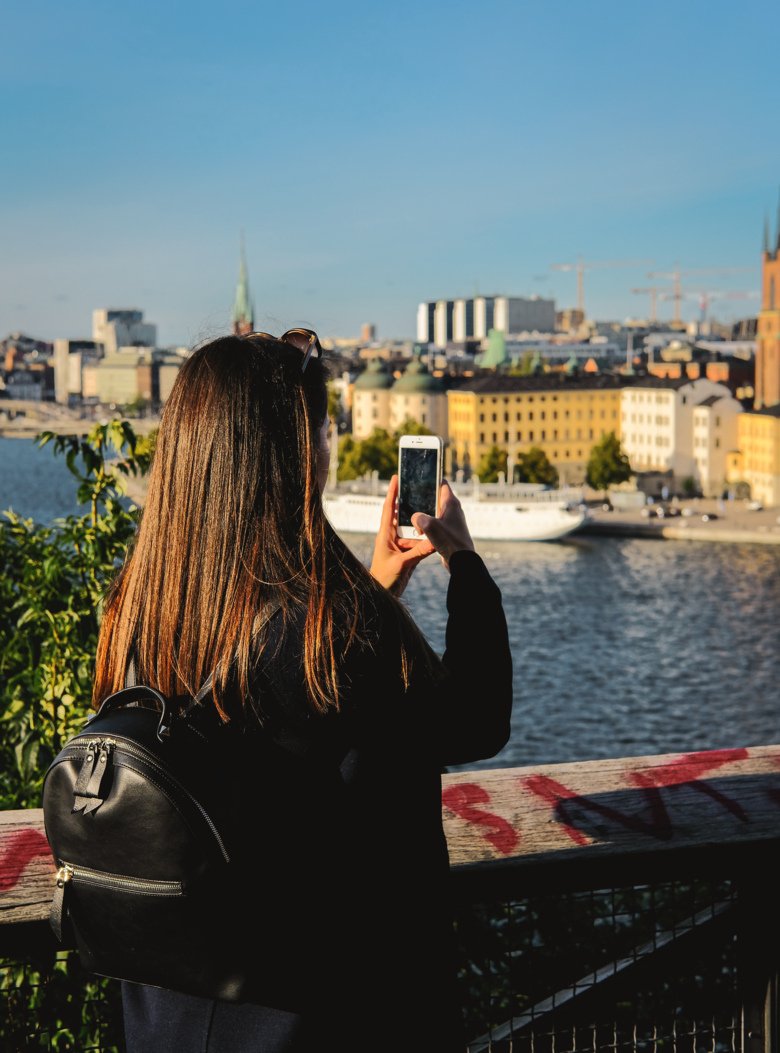 En student tar bild av Stockholm skyline med sin mobil.