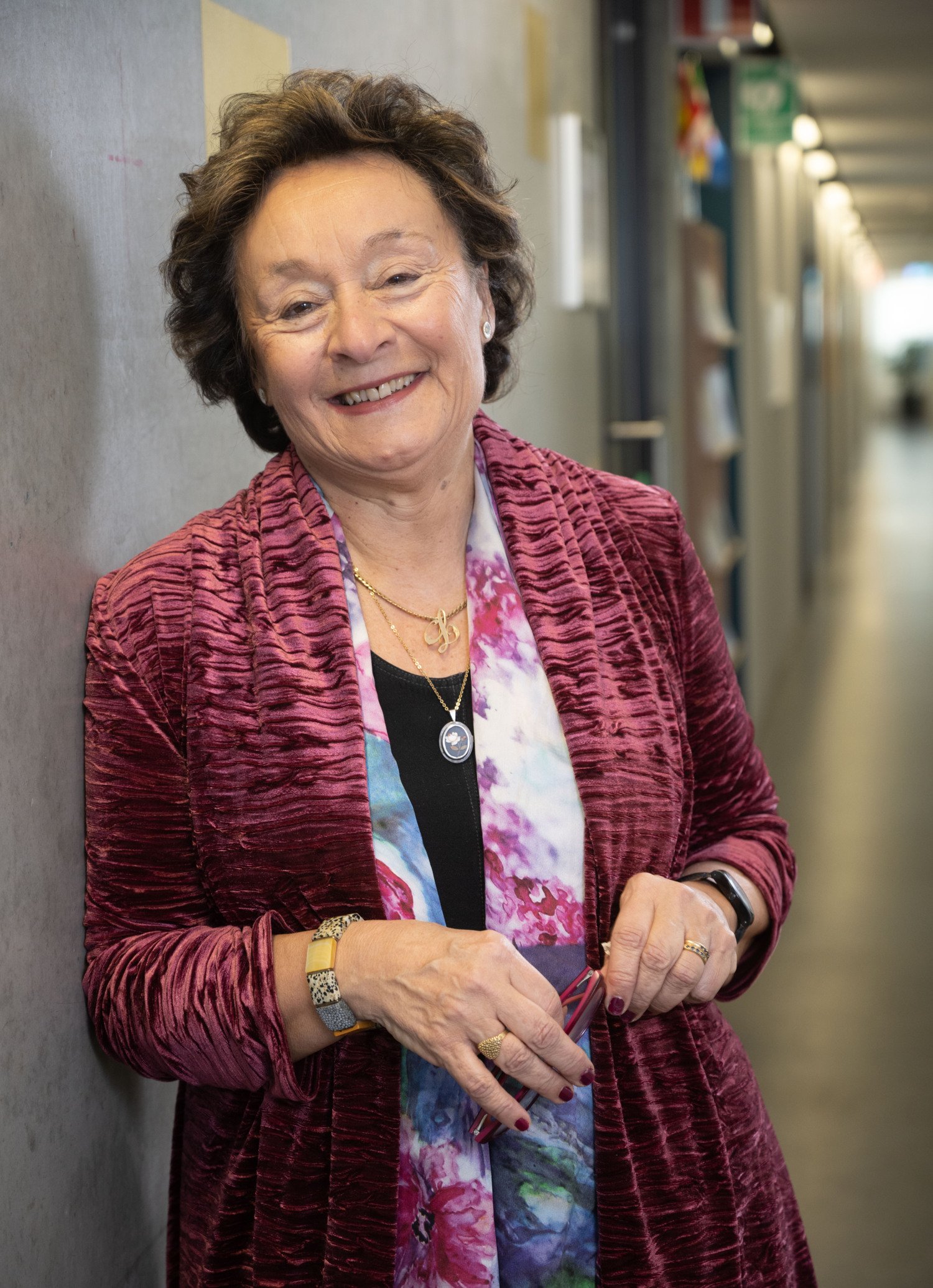 Porträtt av äldre kvinna i röd kofta.