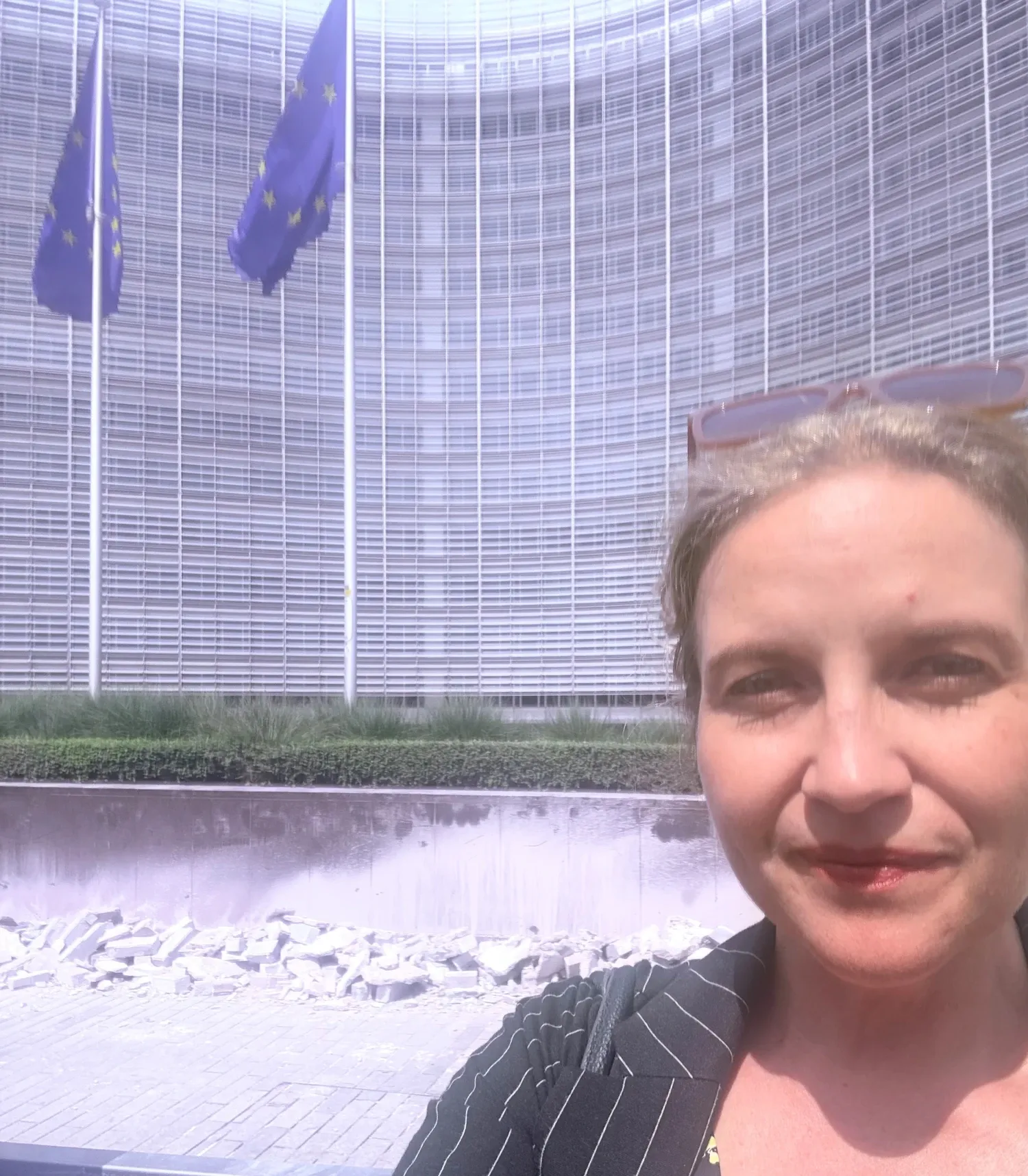 En kvinna står framför en byggnad med EU flaggor framför oss