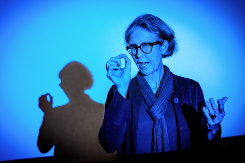 Margareta Bratt Carlström syns föreläsa i det blåa ljuset av en digital skärm.
