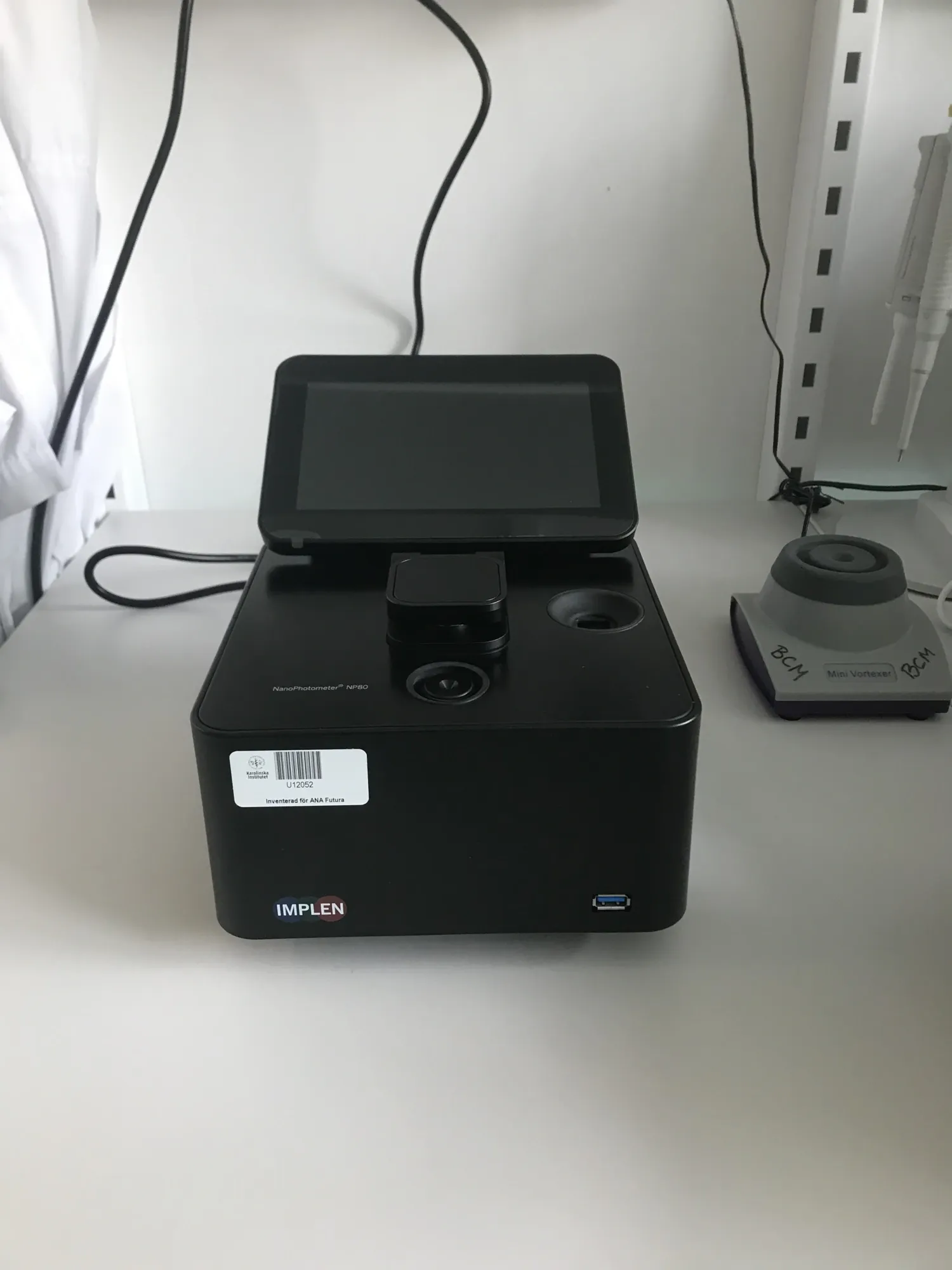 Bild på ett svart NanoPhotometer™ NP80 instrument ståendes på ett bord