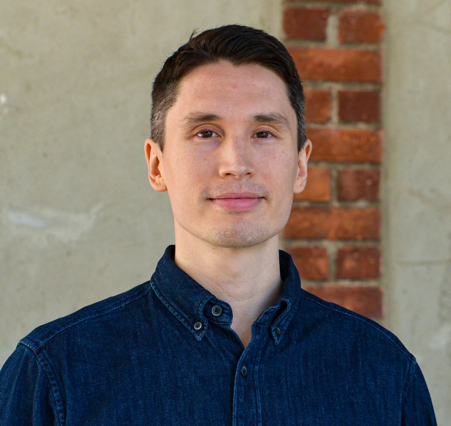 Porträtt av man i blå skjorta.