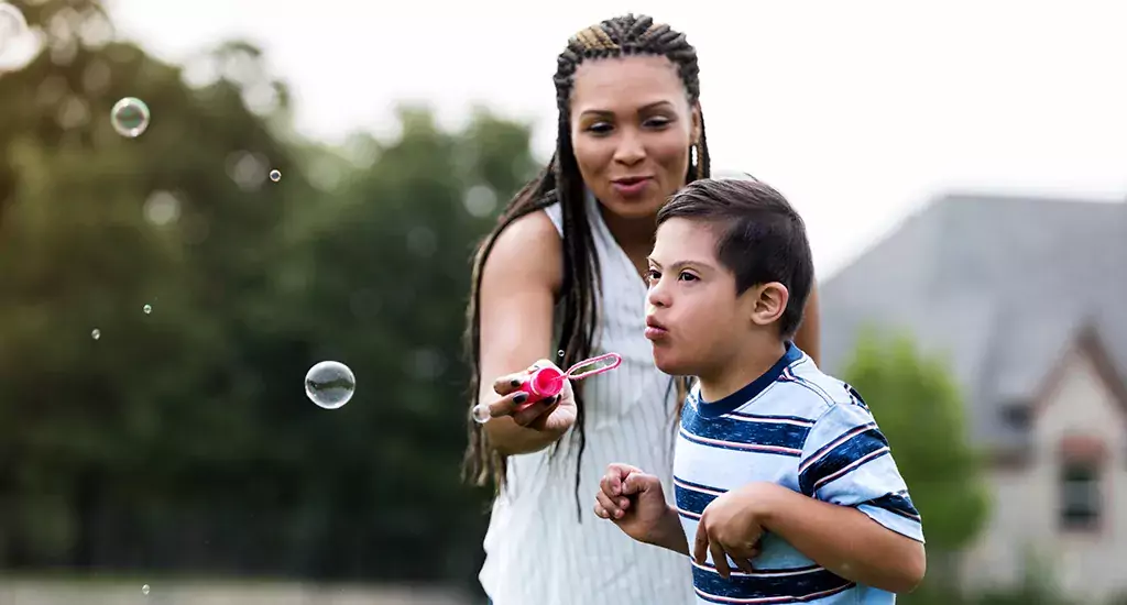 Pojke blåser såpbubblor med sin mamma