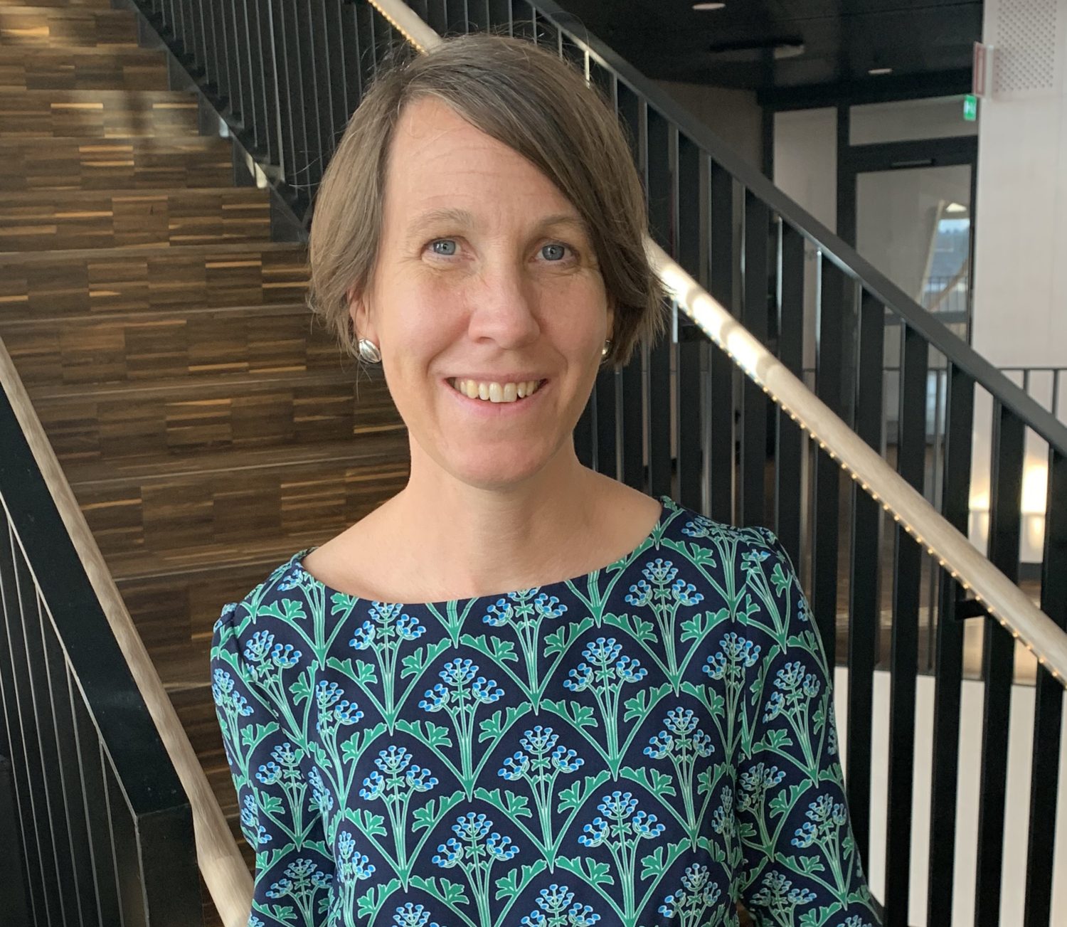 Porträtt av kvinna framför trappa.