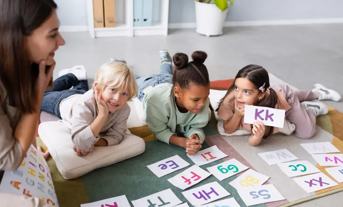 Barn och en lärare med bokstäver.