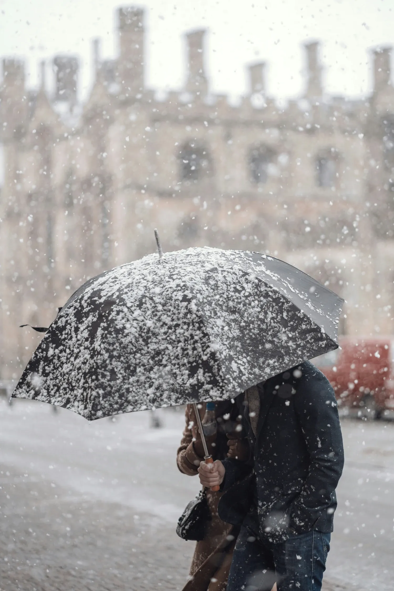 En man går med ett paraply i en snöstorm