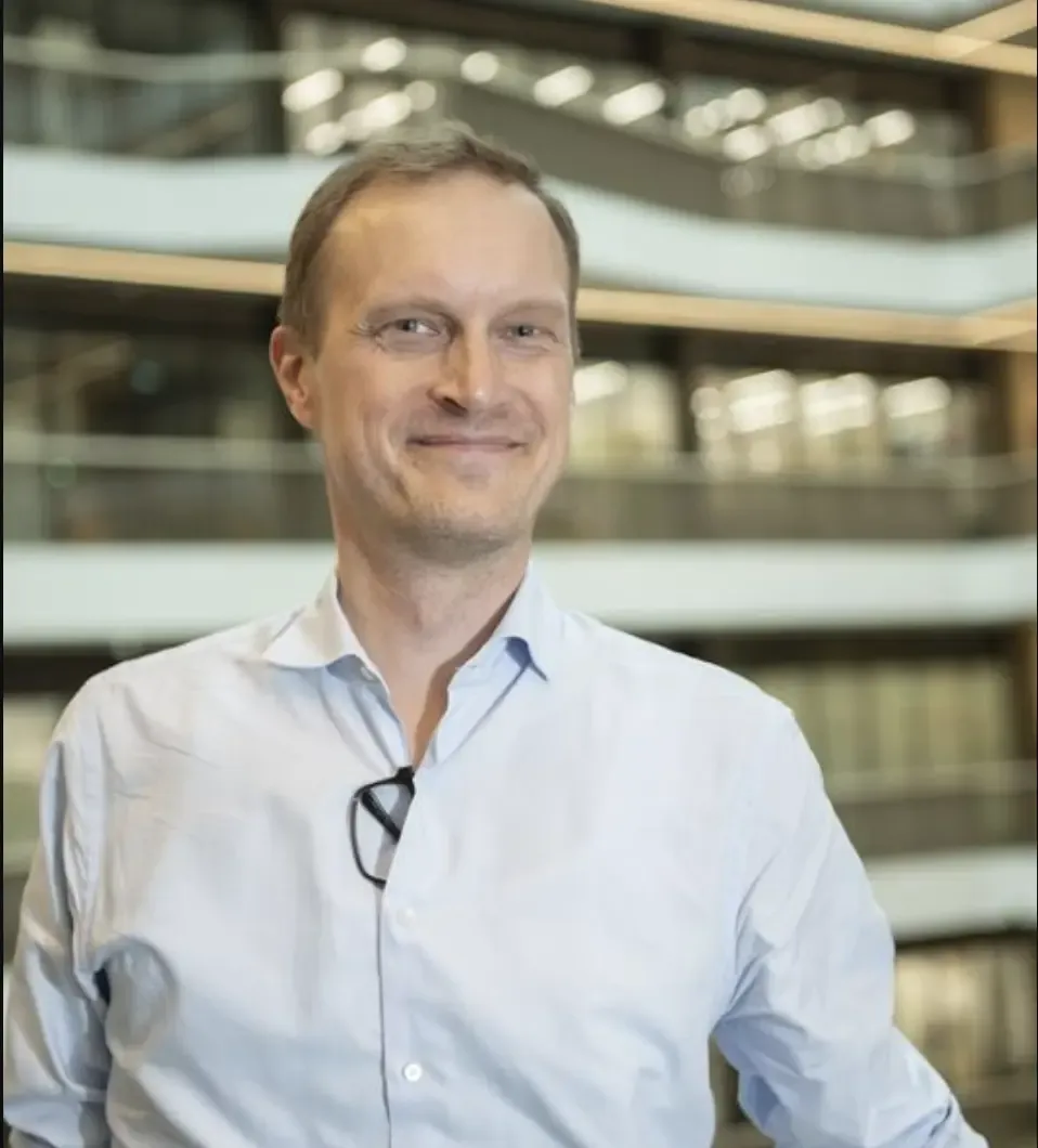 Porträtt av man i blå skjorta.